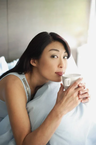 Woman sitting on bed — Stock Photo, Image