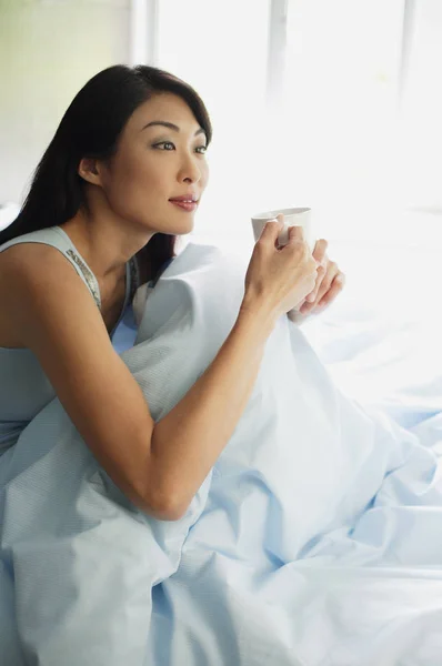Woman sitting up in bed — Stock Photo, Image