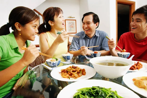 Счастливая азиатская семья с едой — стоковое фото