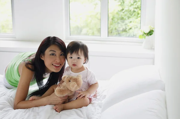 Junges Mädchen sitzt auf dem Bett — Stockfoto