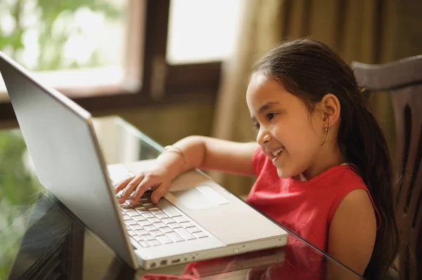 Kleines Mädchen arbeitet am Laptop — Stockfoto