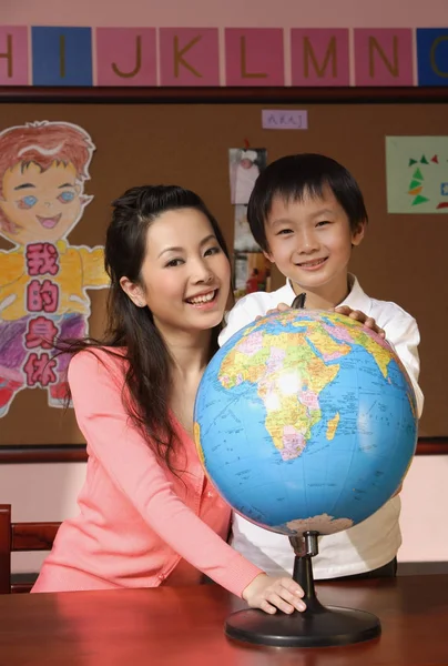 Schoolboy with teacher and globe — Stock Photo, Image