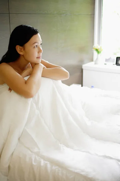 Mulher na cama no quarto moderno — Fotografia de Stock