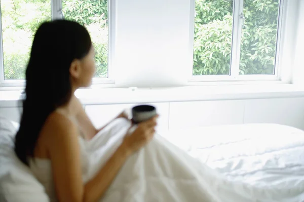 Wanita di tempat tidur dengan cangkir kopi — Stok Foto