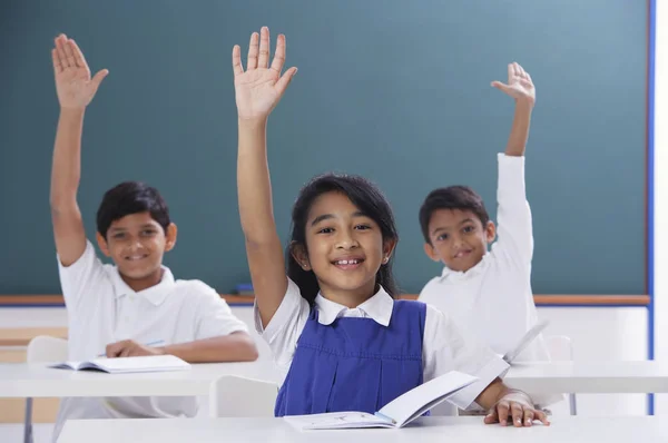 three students with raised hands