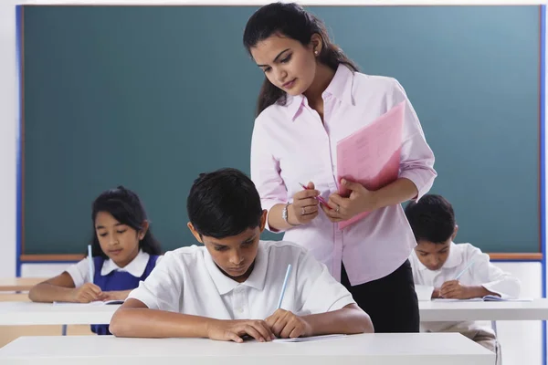 Leraar met uitzicht op schoolwerk — Stockfoto