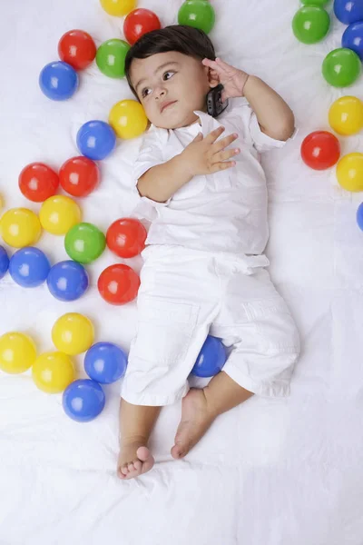 Niño rodeado de pelotas — Foto de Stock