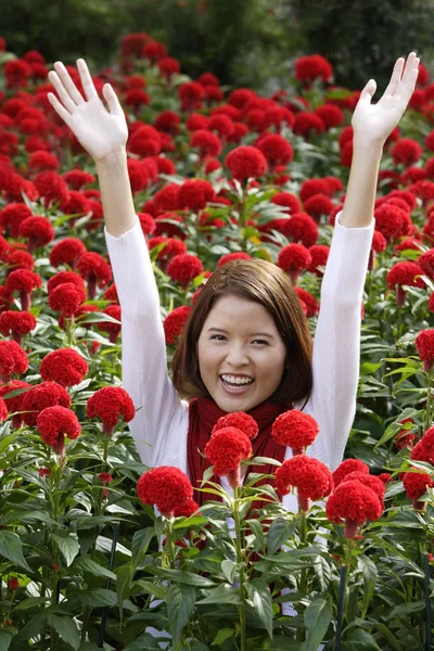 Donna tra i fiori rossi — Foto Stock