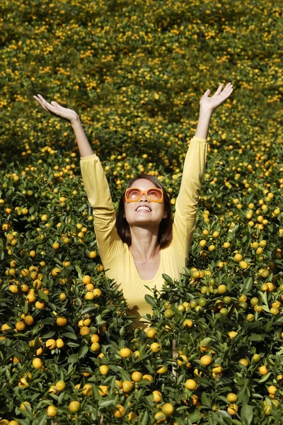 Mulher entre plantas de laranja — Fotografia de Stock