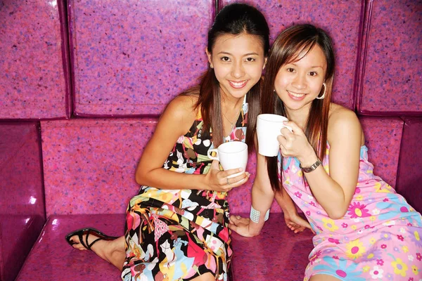 Mujeres en sofá con tazas —  Fotos de Stock