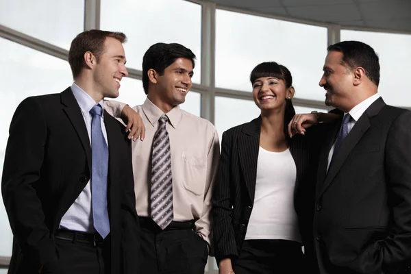 Grupo mixto de carreras sonriéndose entre sí — Foto de Stock