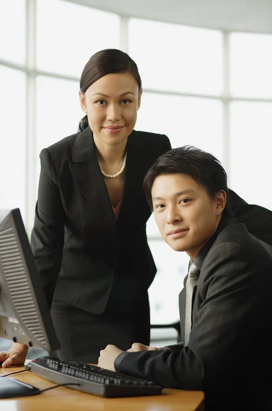 Businesswoman and businessman looking at laptop — Stock Photo, Image