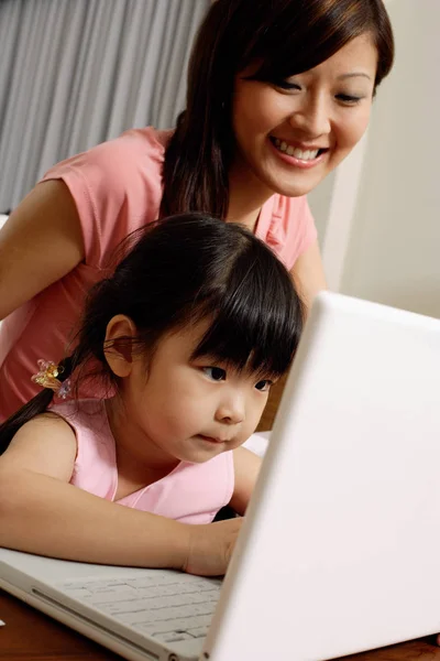 Mother and daughter using laptop Stock Photo