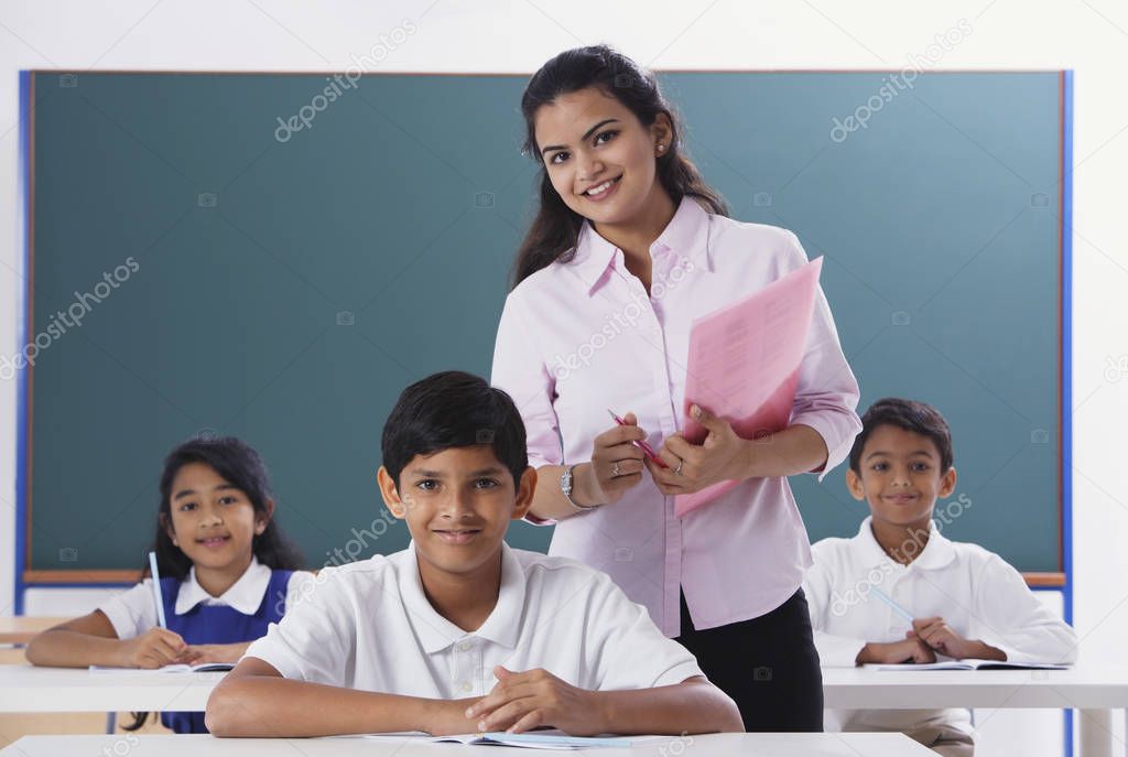 three students and teacher smile at camera