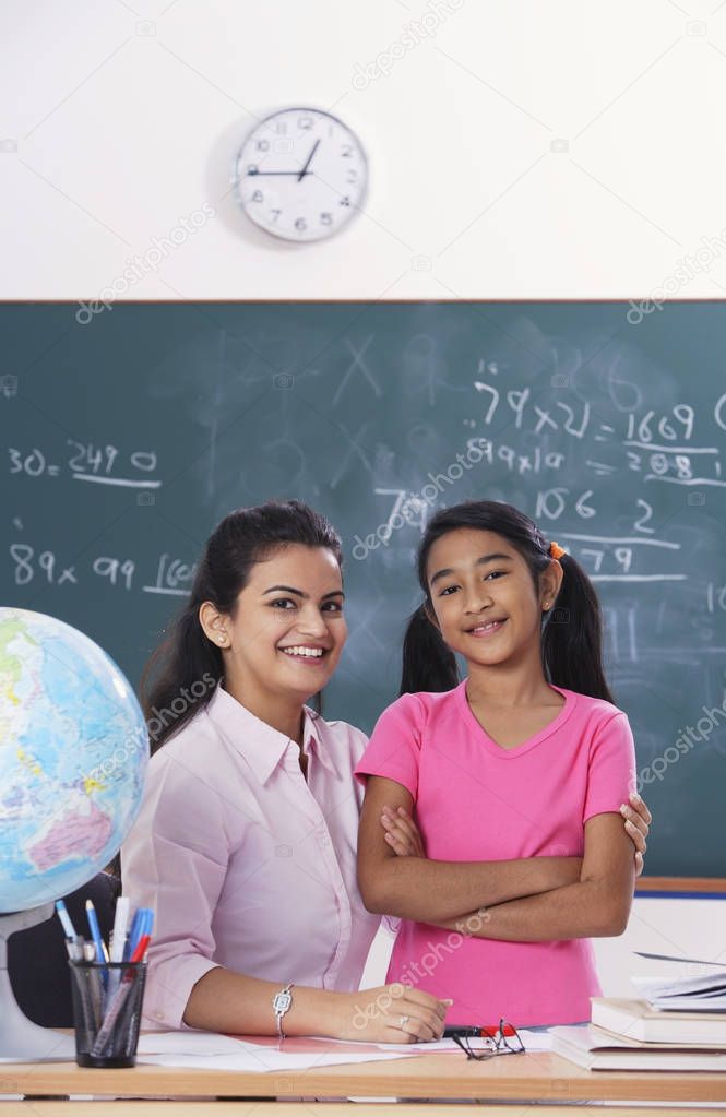 teacher with arm around student, both smiling at camera