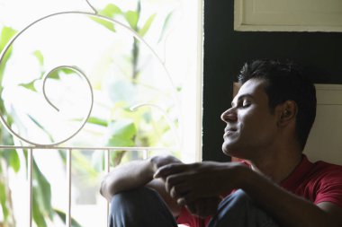 Hintli adam pencereden dışarı bakarak