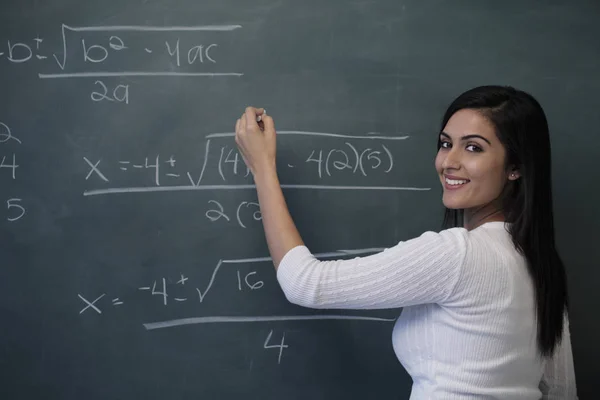 Young female teacher writing — Stock Photo, Image