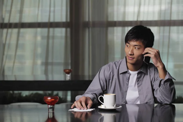 Homme assis à une table — Photo