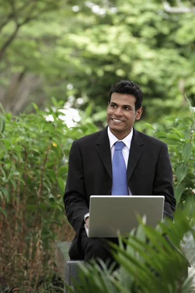 Indian man smiling while working on laptop Royalty Free Stock Photos