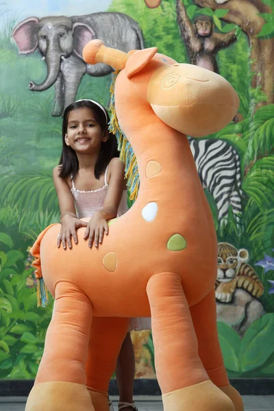 Carino ragazza con Grande giraffa giocattolo — Foto Stock