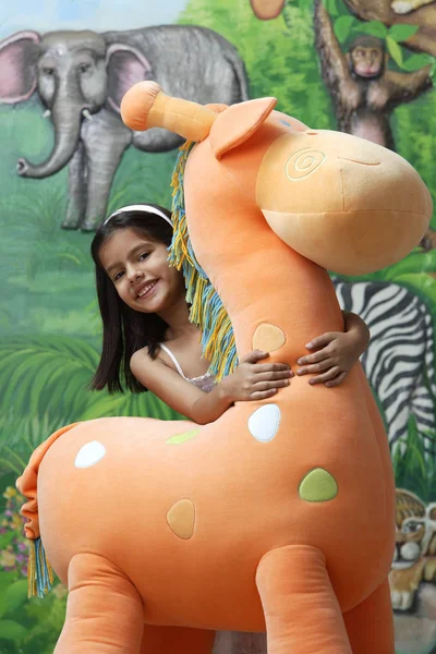 Carino ragazza con Grande giraffa giocattolo — Foto Stock