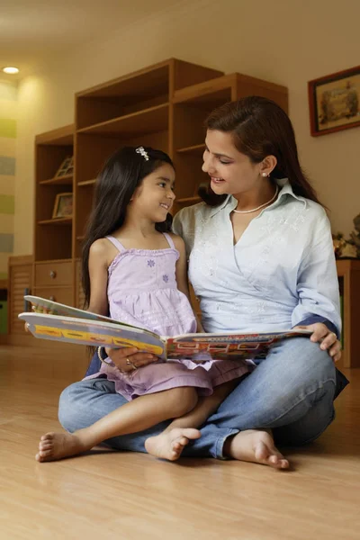 Ragazza lettura libro con madre — Foto Stock