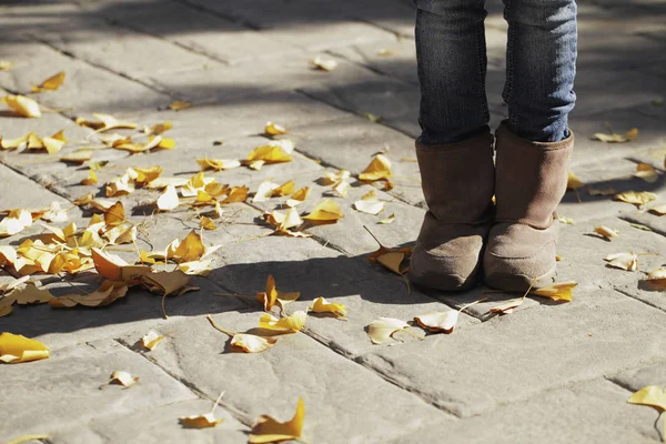 Ноги маленькой девочки с осенними листьями — стоковое фото