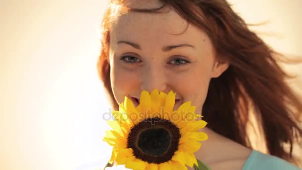 Mujer con cabello rojo sosteniendo girasol — Vídeo de stock