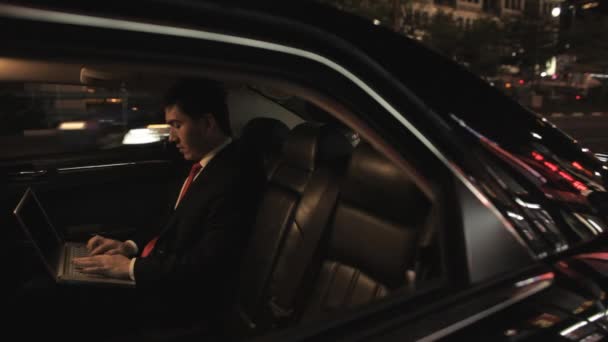 Бизнесмен сидит на заднем сидении автомобиля — стоковое видео