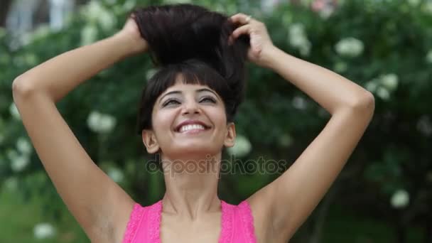 Žena s úsměvem a dotýká její vlasy — Stock video