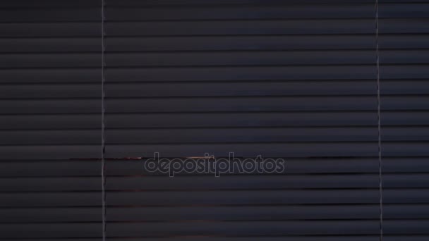 Человек, открывающий шторы и выглядывающий наружу — стоковое видео