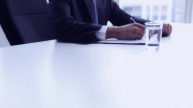 Businessman writing in folder