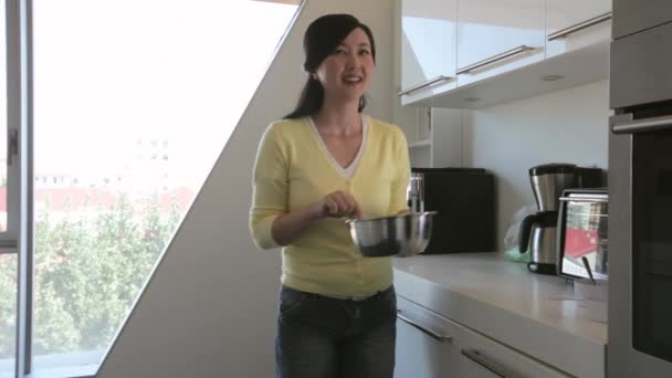 Молодая женщина приготовление пищи на кухне — стоковое видео