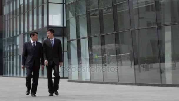 Businessmen walking towards building — Stock Video