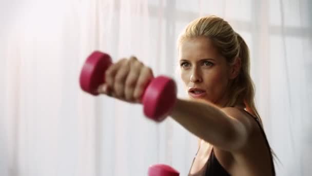Nő súlyzókkal gyakorol — Stock videók