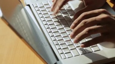 Laptop klavyesinde yazan kişi