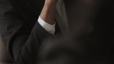 Gülümseyerek, ofiste oturan işadamı