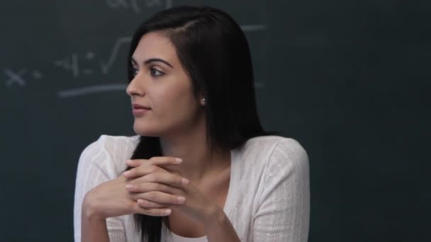 Woman sitting in front of blackboard — Stock Video