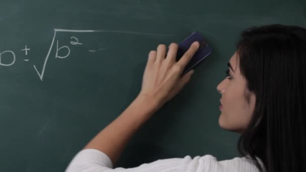 Женщина стирает математическую формулу — стоковое видео
