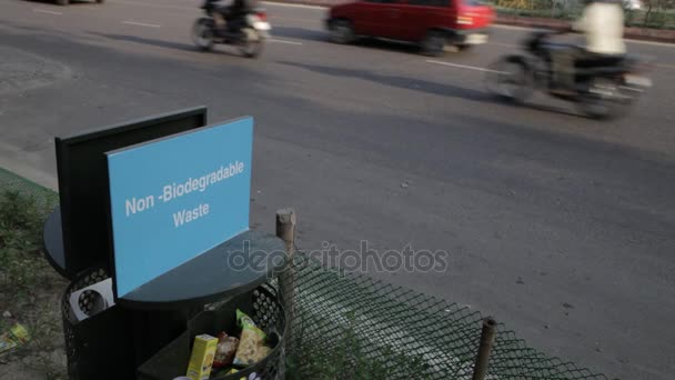 Szemétkosárban, forgalmas út szélén nem biogradable hulladék / India — Stock videók