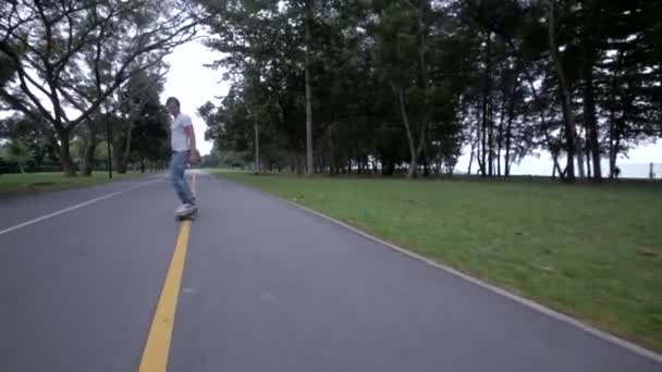 Człowiek, skateboarding w dół drogi — Wideo stockowe