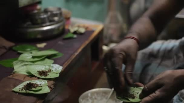 Человек, заворачивающий орехи бетель в листья / Индия — стоковое видео