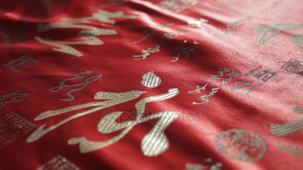 Escrita chinesa vermelha em tecido de seda — Vídeo de Stock