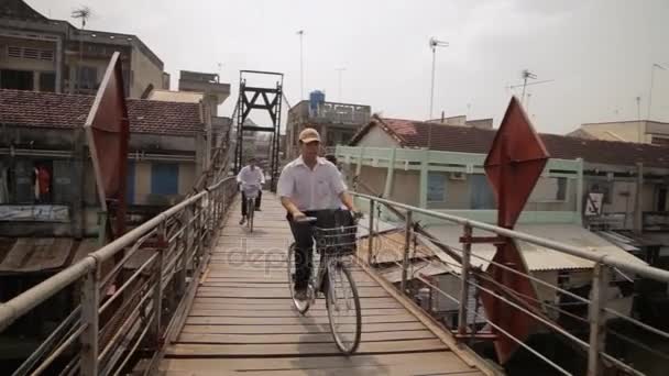 Kerékpárosok és emberek gyaloglás legyőz fa híd — Stock videók