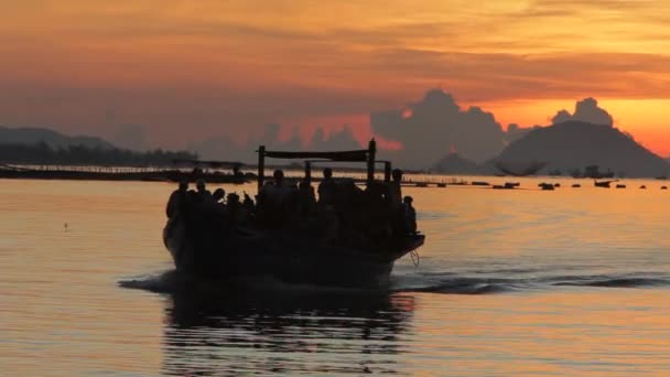 Aveia Cheio de pessoas passando pelo pôr do sol — Vídeo de Stock