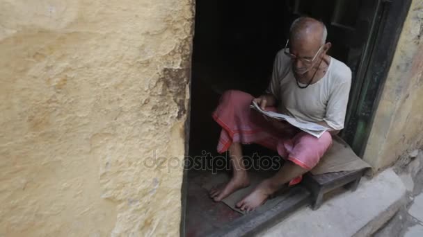 Hombre sentado en la puerta — Vídeos de Stock