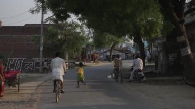 İnsanlar Bisiklet köy yolu aşağı sürme