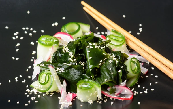 Ensalada de wakame en plato negro —  Fotos de Stock