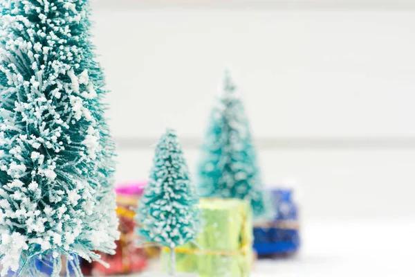 Julgranar med vit snö och gåva lådor - selektiv fokus — Stockfoto