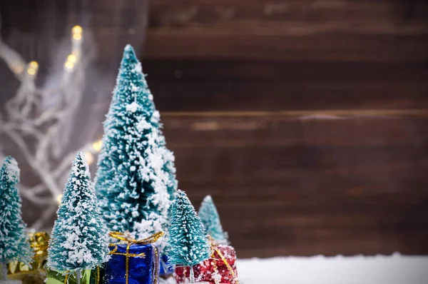 Árboles de Navidad con nieve blanca y cajas de regalo - enfoque selectivo — Foto de Stock